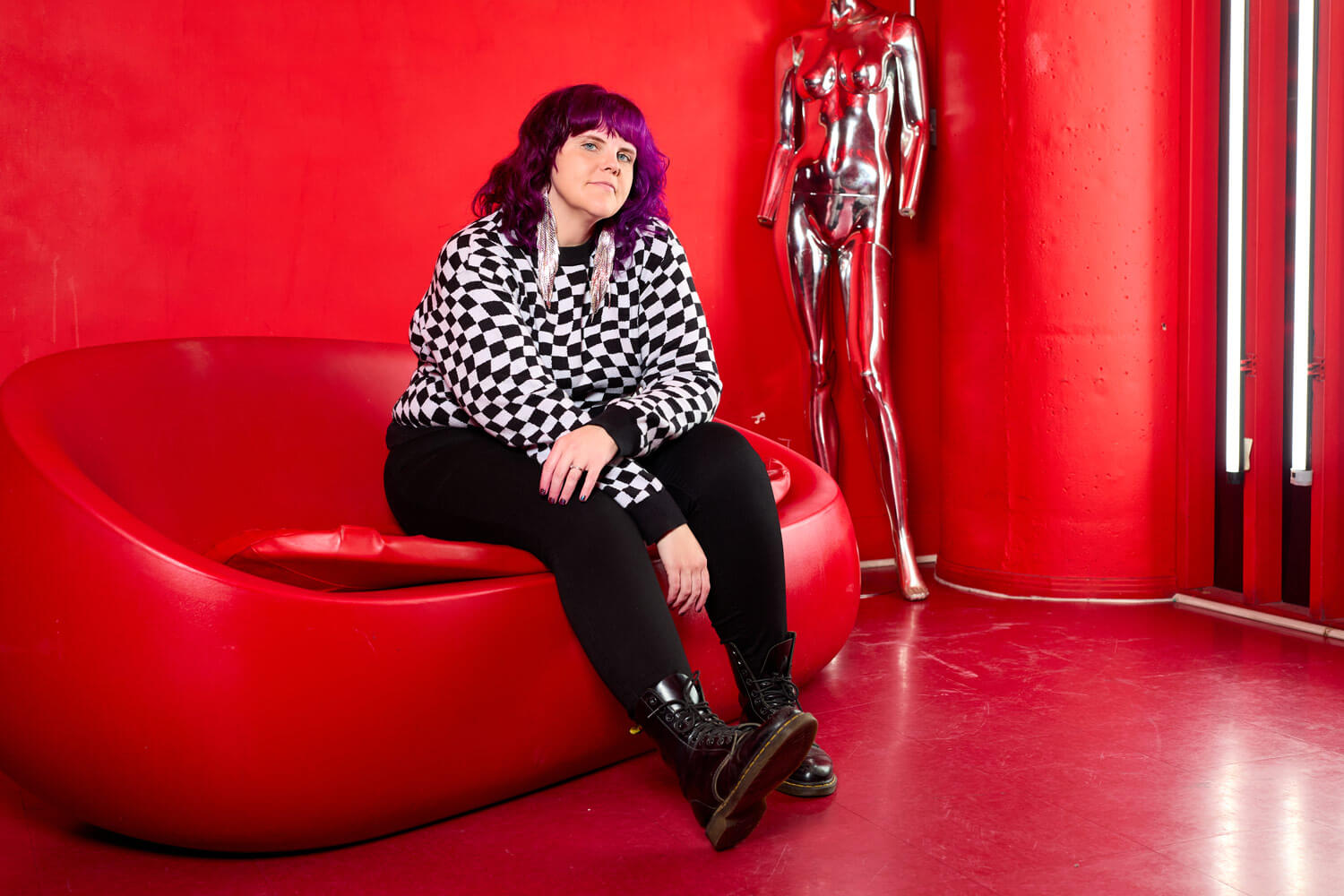 Brand innovation expert, Megan Gersch, sitting in a red room on a couch